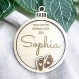 Holzkugel für Babys erstes Weihnachten mit dem Namen Sophia, Babyfußgravur und Jahreszahl.