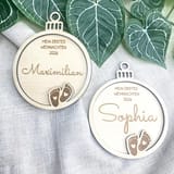 Zwei personalisierte Holzkugeln mit den Namen Maximilian und Sophia auf hellem Stoff.