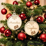 Holzkugeln Maximilian und Sophia zwischen roten Christbaumkugeln.