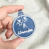 Eine Hand hält eine blaue Alexander-Kugel.