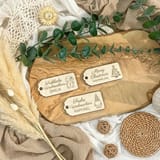 Gravierte Holz-Geschenkanhänger mit Tannenzweigen auf hellem Untergrund.