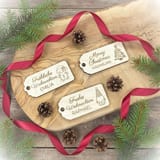 Holz-Geschenkanhänger mit rotem Geschenkband auf einem Paket.