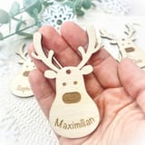 Eine Hand hält den Holzrentier-Anhänger Maximilian.