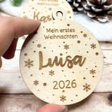 Holzanhänger Mein erstes Weihnachten mit dem Namen Luisa und der Jahreszahl 2026 in einer Hand