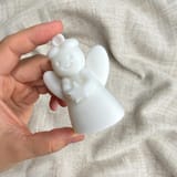 Weißer Sternengel schräg von vorn in einer Hand