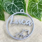 Helle Weihnachtskugel mit dem Namen Luca vor Efeu