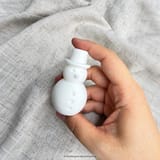 Weißer Schneemann aus seitlicher Perspektive in einer Hand