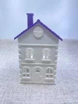 Gedrucktes weißes Stadthaus mit violettem Dach in Vorderansicht