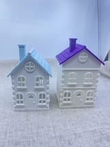 Giebelhaus mit blauem Dach und Stadthaus mit violettem Dach nebeneinander