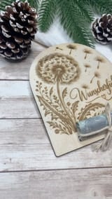 Unverändertes Originalfoto von Ninas gelasertem Pusteblumen-Wunscherfüller mit Geldschein; rechts angeschnitten
