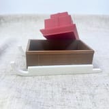 Originalfoto des geöffneten Geschenkschlittens mit angehobenem rotem Geschenkdeckel; das braune Fach ist sichtbar.