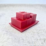 Originalfoto des abgenommenen roten Geschenkdeckels mit plastischen Päckchen, Geschenkbändern und Schleifen.