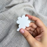 Weißes vierblättriges Kleeblatt in einer Hand