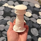 Cremefarbener Leuchtturm-Fotohalter in einer Hand