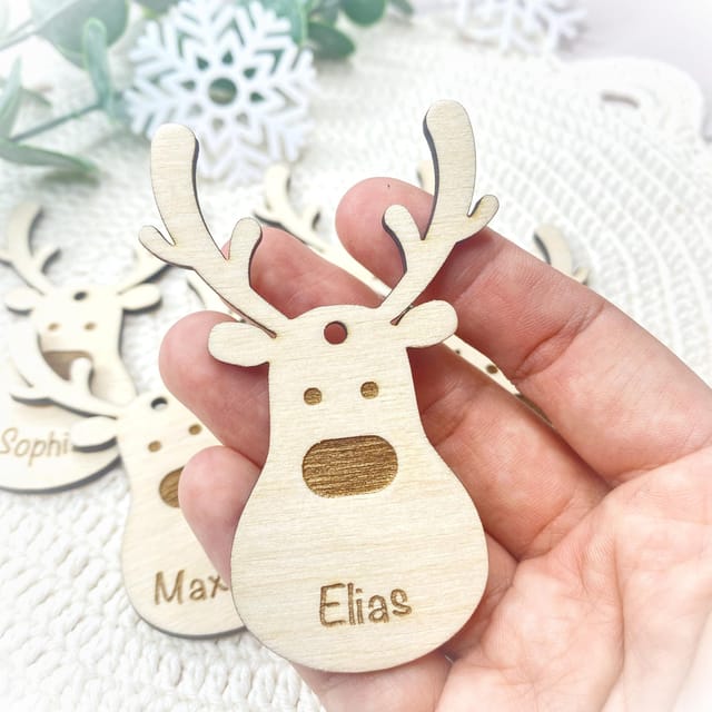 Eine Hand hält den personalisierten Holzrentier-Anhänger Elias.