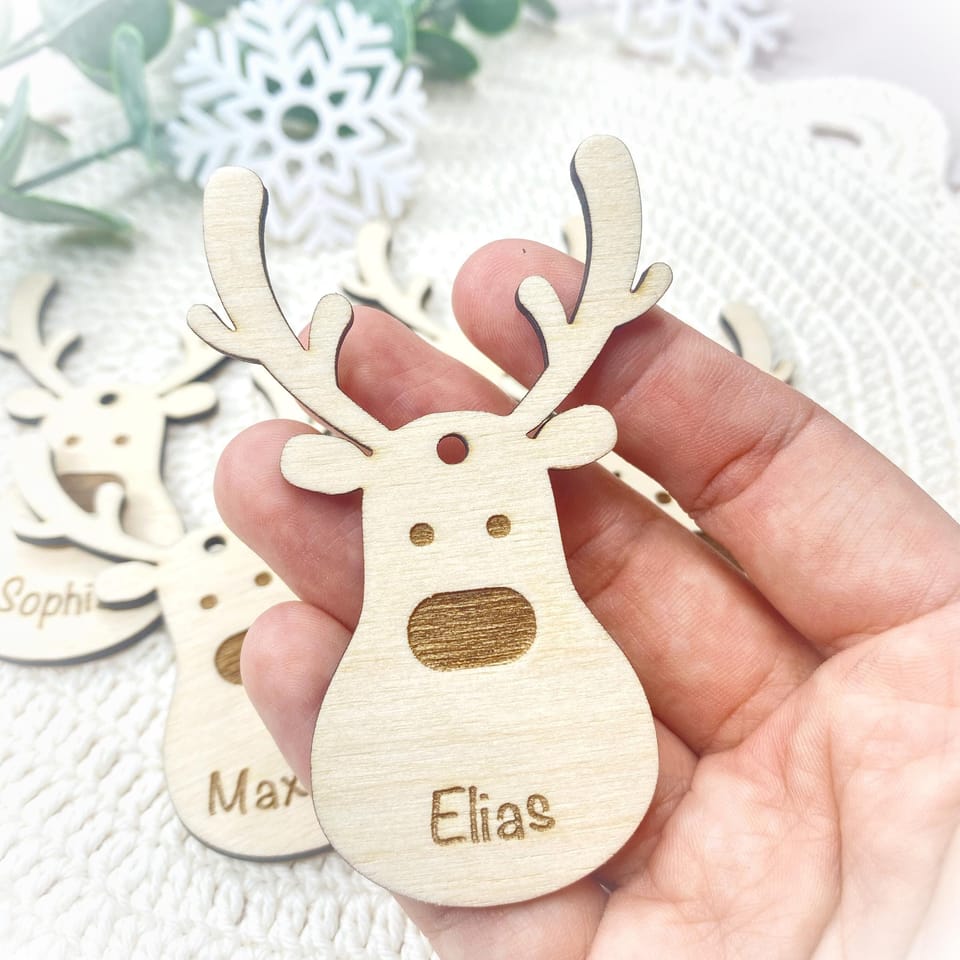 Eine Hand hält den personalisierten Holzrentier-Anhänger Elias.